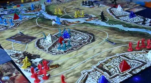 Bitwa o Kemet! Żółte, czerwone i niebieskie figurki walczą o kontrolę nad starożytnym lądem.