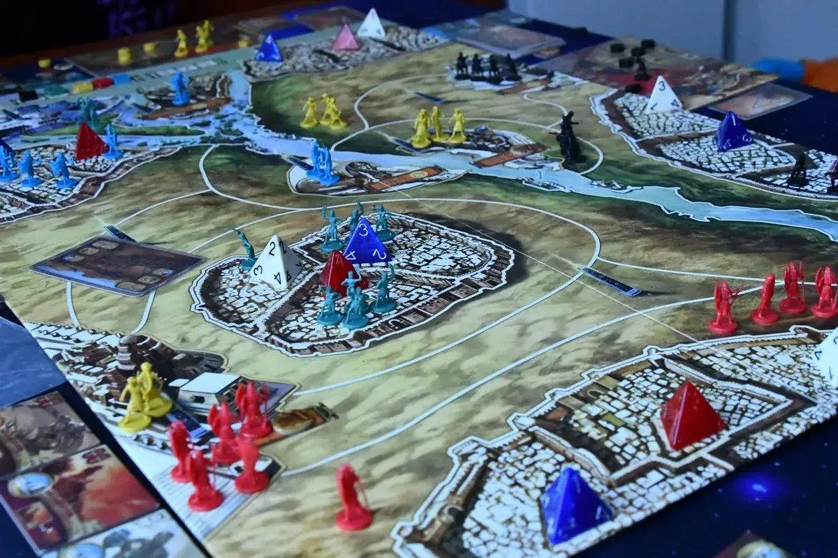 Bitwa o Kemet! Żółte, czerwone i niebieskie figurki walczą o kontrolę nad starożytnym lądem.