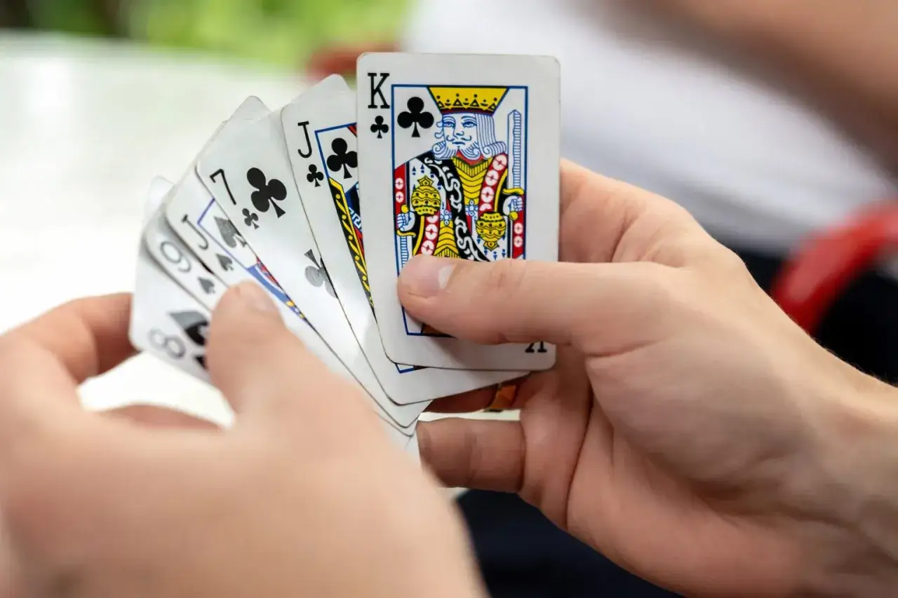 Ręka trzyma karty do gry: Król, Walet, 7, 6, 8. Czy to ręka dla durenia, czy dla króla?