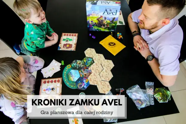 Rodzina gra w "Kroniki zamku Avel". Dzieci i ojciec budują planszę, tworząc wspólną przygodę.